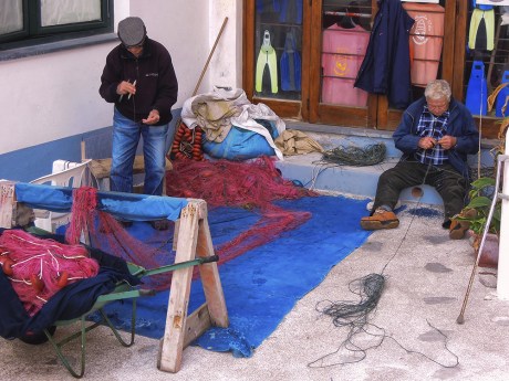pescatori che riparano le reti
